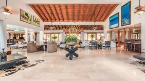 A spacious lobby with a high ceiling, wooden beams, and a central plant display. - Wonderful Villa w Style at Colinas Casa de Campo (La Romana)