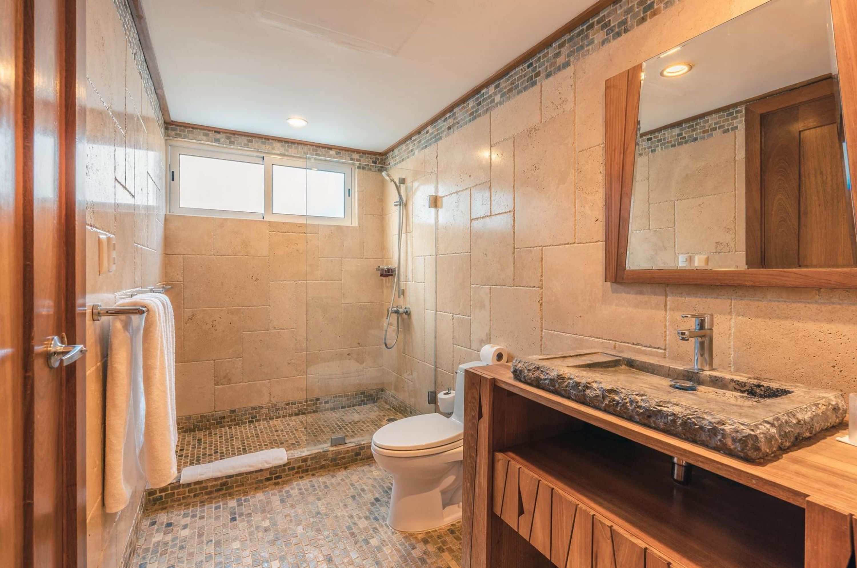 Une salle de bain avec douche, toilettes et lavabo.