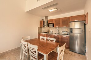 A compact kitchen with wooden cabinets, a stainless steel refrigerator, a microwave, and a gas stove. - 5 Guests 2 BR Jacuzzy Balcony Sublime (Las Terrenas)