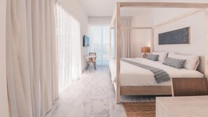 A modern hotel room with a four-poster bed, a small table with a chair, a lamp, and a view of the city through large windows. - 3br-penthouse w Jacuzzi Incl at Lake View (Las Terrenas)
