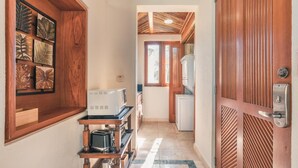 A narrow hallway with a wooden door on the right, a microwave, a coffee maker, and a small refrigerator. - Tropical Villa With Pool at Green Village B843 (Punta Cana)