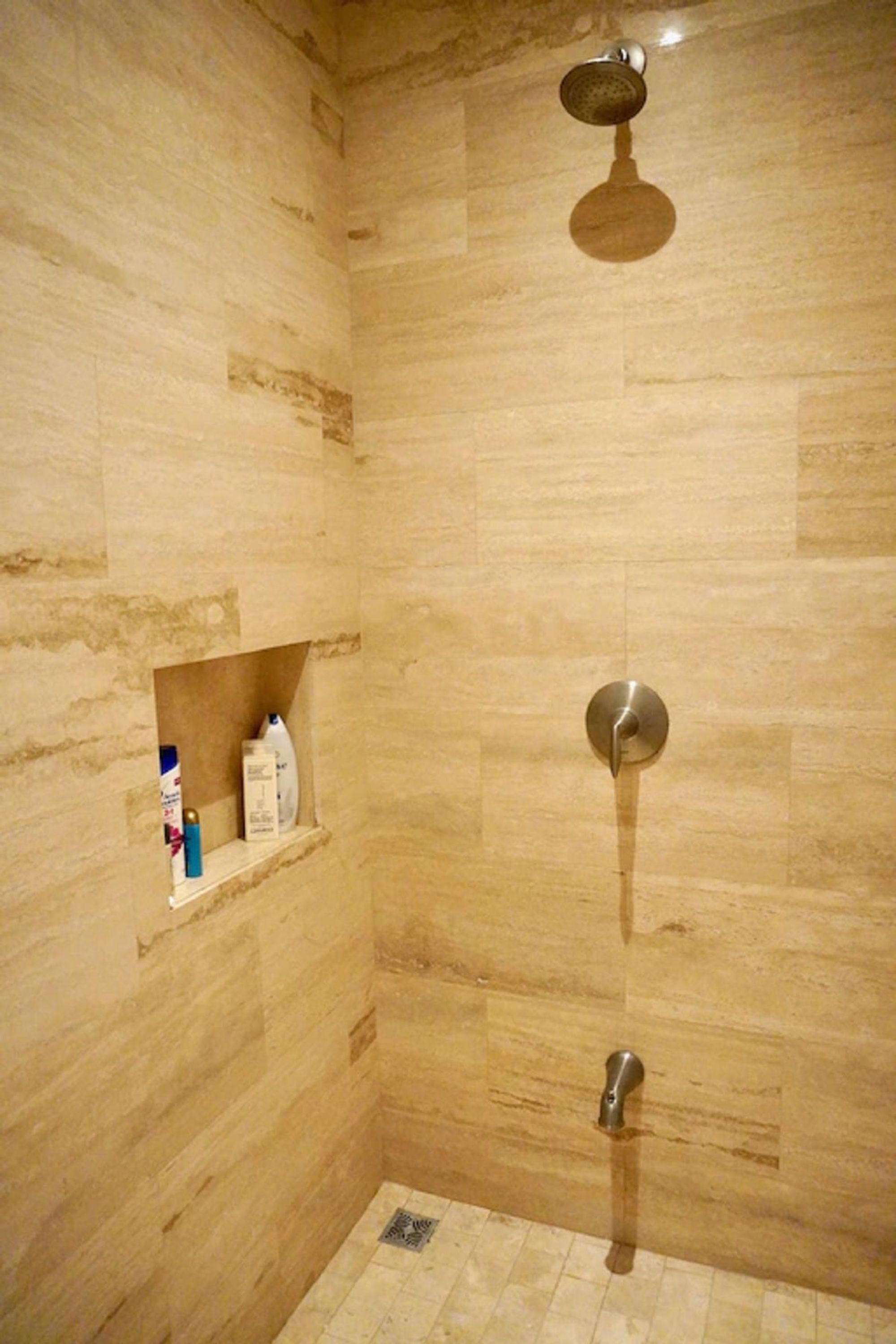 Ducha con grifo empotrado y cabezal de ducha de mano.