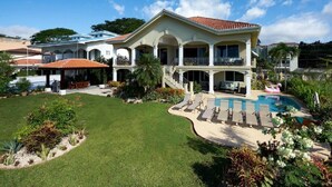 A large, two-story house with a swimming pool, a covered patio, and a well-maintained lawn. - Beachfront Potrero Nice 7-br Villa Chef Included - Casa Royal (Tempate)