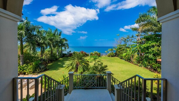 A view from a balcony with a staircase leading to a grassy area, overlooking a beach and ocean. - Beachfront Potrero Nice 7-br Villa Chef Included - Casa Royal (Tempate)