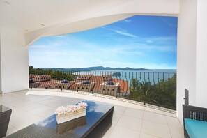 A balcony with a view of a coastal landscape, including a body of water and distant mountains. - Oceanview Balcony 2 Pools Parking Kitchen Washer D - Flamingo Towers 17 (Cabo Velas)