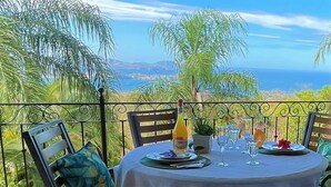 Een tafel gedekt voor twee met uitzicht op de oceaan en palmbomen.