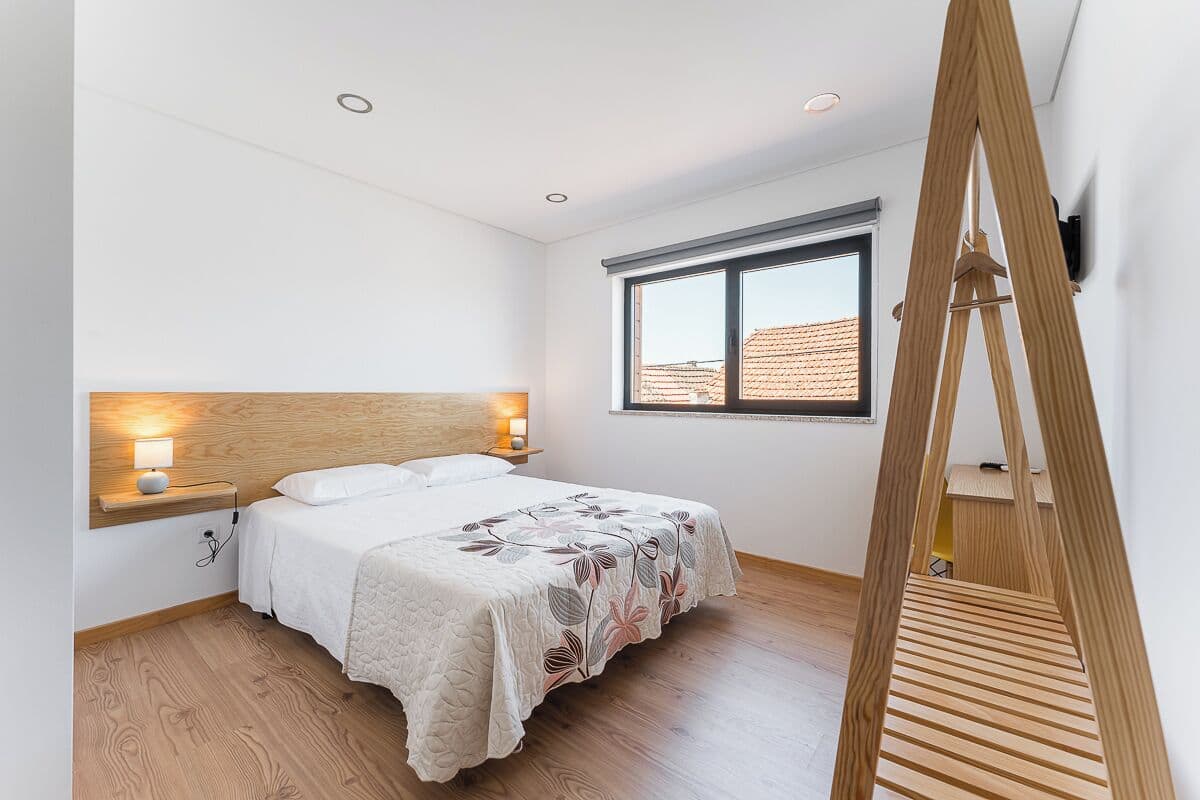 Une chambre à coucher avec un lit, des lampes de chevet, une fenêtre et une échelle en bois.