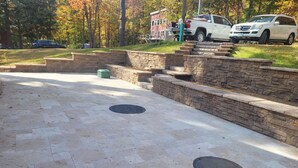 Un espacio al aire libre con superficie pavimentada y escalones de piedra que conducen a un edificio.