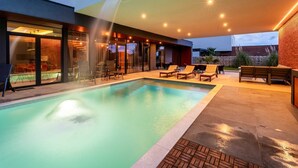 A modern outdoor pool area with lounge chairs and a covered seating area. - Luxury Villa Aurealis with Pool (Ližnjan)