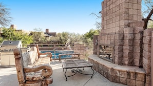A backyard with a pool, a barbecue grill, a wooden bench, and a stone wall. - Refreshing Desert Oasis: View, Sparkling Pool, Massage Chair, Remote Work Ready (Tucson)