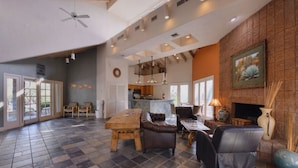 A spacious living area with a fireplace, a dining table, and comfortable seating. - Refreshing Desert Oasis: View, Sparkling Pool, Massage Chair, Remote Work Ready (Tucson)