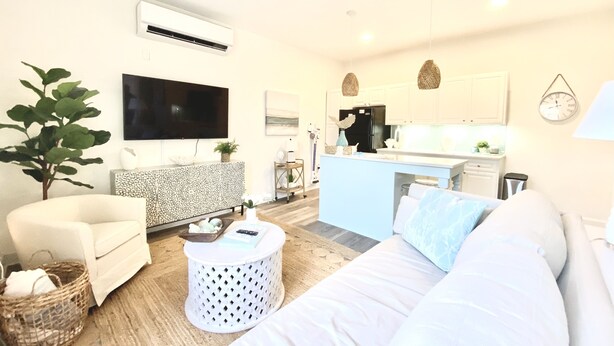 Una sala de estar moderna con un sofá, una mesa de centro y un televisor.