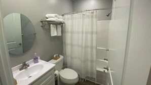 Un baño con inodoro, lavabo y cortina de ducha.