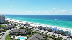 A coastal hotel with a swimming pool, beachfront view, and a parking lot. - Location, location, location! Steps to the pool and just a 5-minute walk to the beach 🏖️💦 (Miramar Beach)