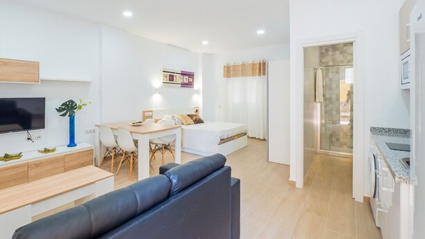 A modern, well-lit apartment with a living room, dining area, and kitchen. - Cubo's Urban Studio Turisbelen / city / free wifi (Málaga)