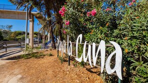 A sign with the name 'Playa Cana' surrounded by lush greenery and flowers. - Cubo's Luna Beach Mijas Costa / Close to the beach / free wifi (Mijas Costa)