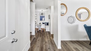 A hallway with a wooden floor, white walls, and a dining area with a table and chairs. - Best Little Bunkhouse in TX! Walk to FIFA WORLD CUP (Arlington)