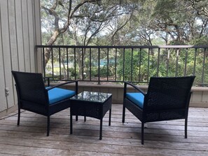 Relax in a serene outdoor space with two comfortable chairs and a glass table.