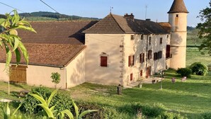 A traditional building with a tower, a tiled roof, and a grassy courtyard.