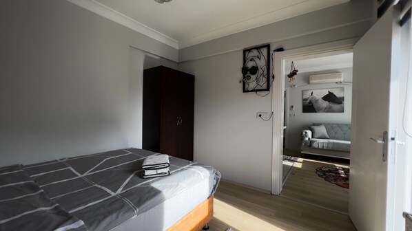 Un dormitorio con cama, armario y puerta que da a otra habitación.