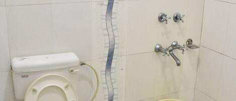 Un baño con inodoro, bidé y ducha.