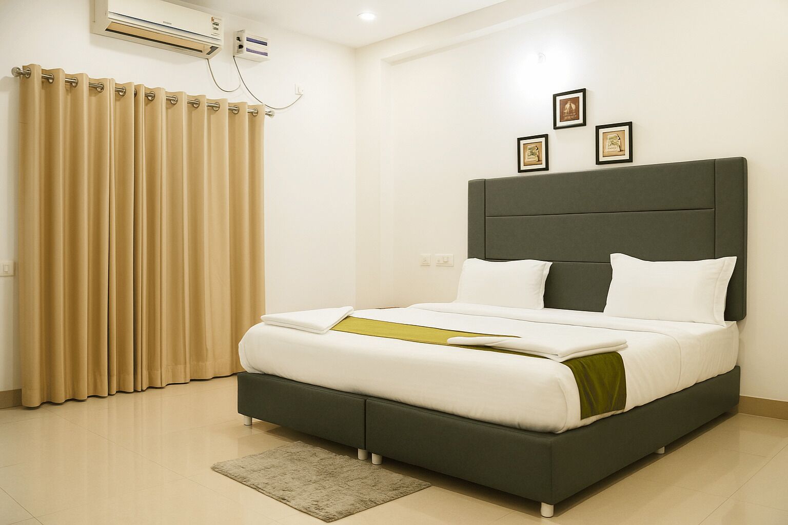 A modern hotel room with a large bed, a grey headboard, and beige curtains.