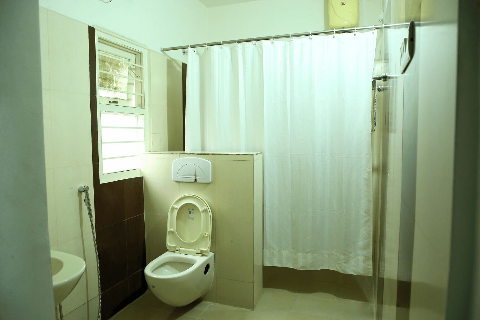 Un baño pequeño con inodoro, ducha y ventana.
