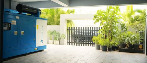 A clean, modern indoor space with a blue utility room, potted plants, and a gated entrance.