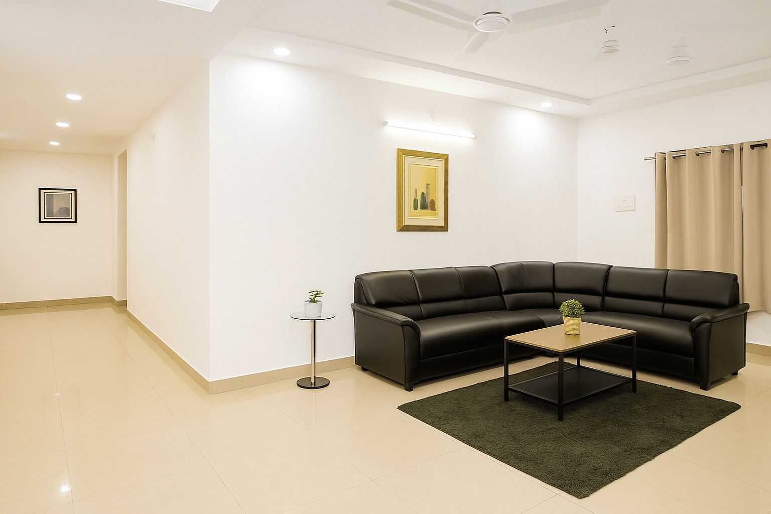Ein modernes Wohnzimmer mit einem schwarzen Ledersofa, einem kleinen runden Couchtisch und einer Stehlampe.