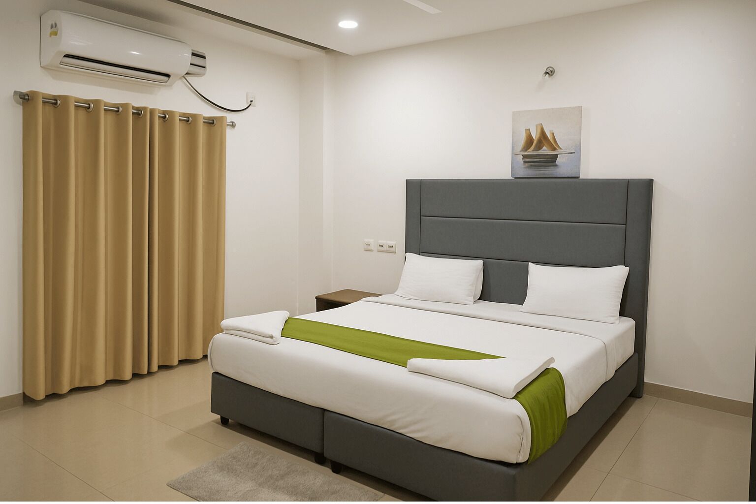 A modern hotel room with a large bed, a grey headboard, and a beige curtain.