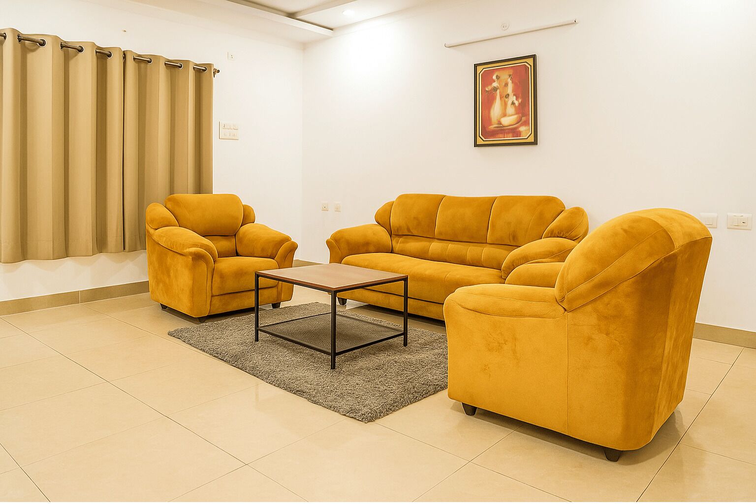 A living room with two mustard-colored sofas, a small wooden coffee table, and a grey rug.