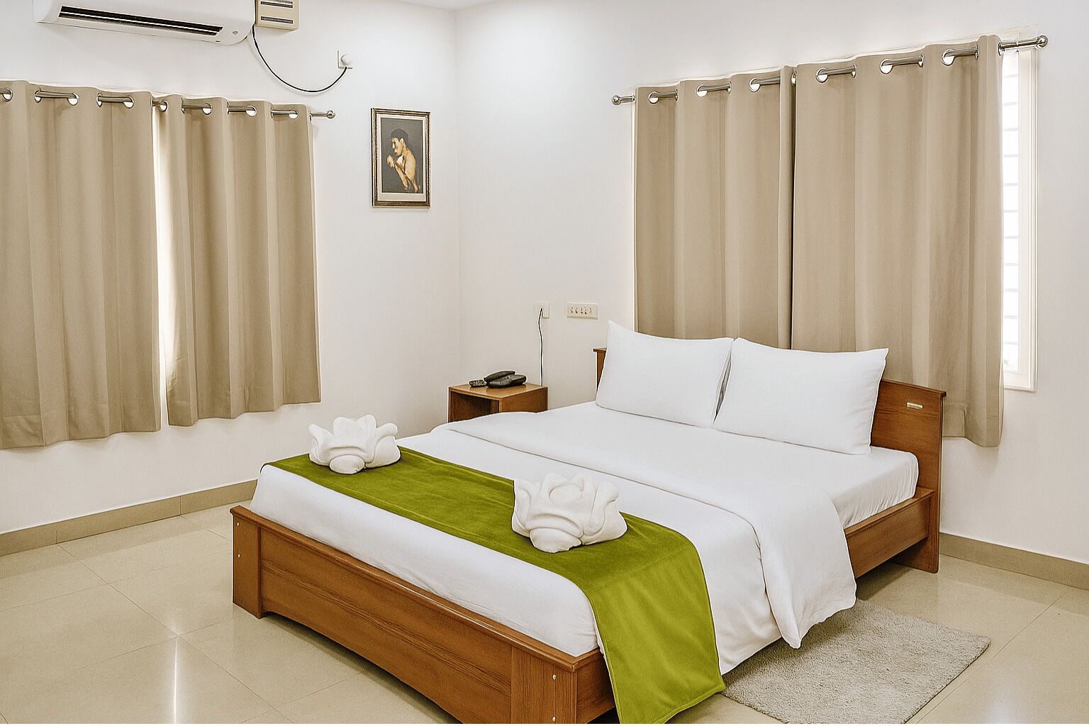 Ein Hotelzimmer mit einem hölzernen Bett, beigen Vorhängen, einer grünen Decke und einem gerahmten Bild an der Wand.