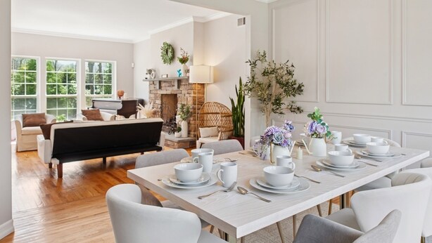 A dining area with a long table set for six, surrounded by white chairs. - NEW DECK!  Private 1 Acre Family Friendly Home - Heated Pool, Home Office & Gym (Westhampton)