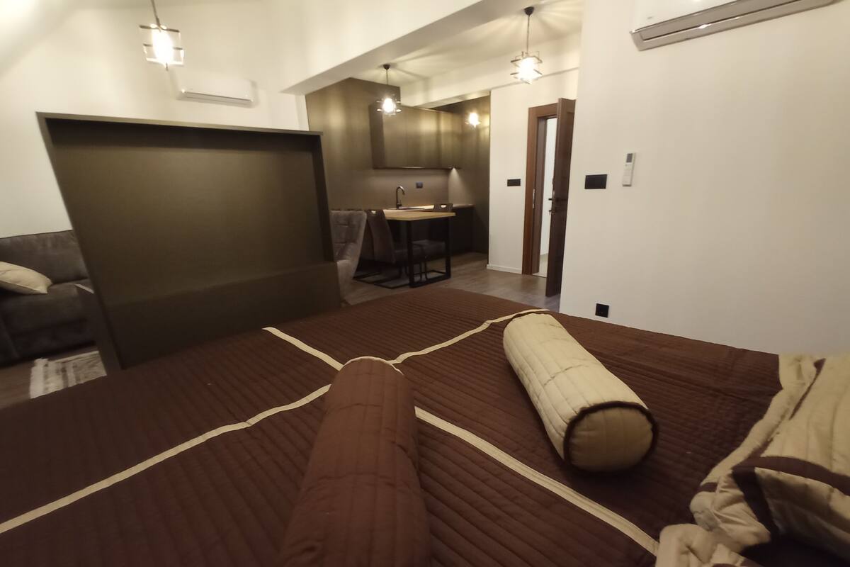 Ein modernes Hotelzimmer mit einem großen Bett, einer Couch, einem Schreibtisch und einer Küchenzeile.