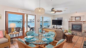 A spacious living room with a glass table, wicker furniture, a fireplace, and a TV. - Best View in Mission Bay, California (San Diego)