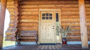 A wooden cabin with a front door, a porch, and a bench. - Hill Cabin Hideaway, Romantic! Country Cabin for 2 (North Powder)