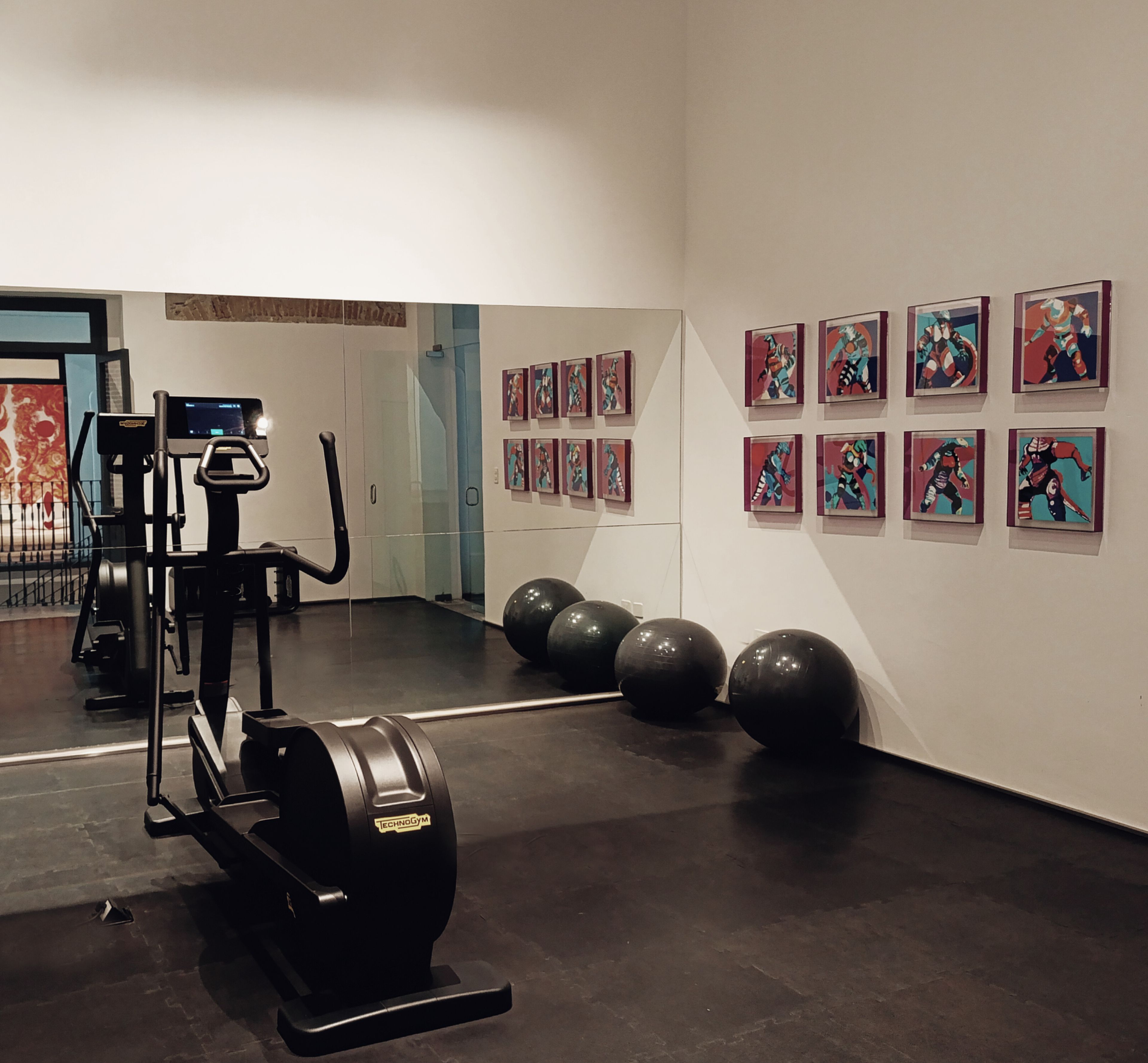 Un gimnasio con equipo de ejercicio y un espejo grande.