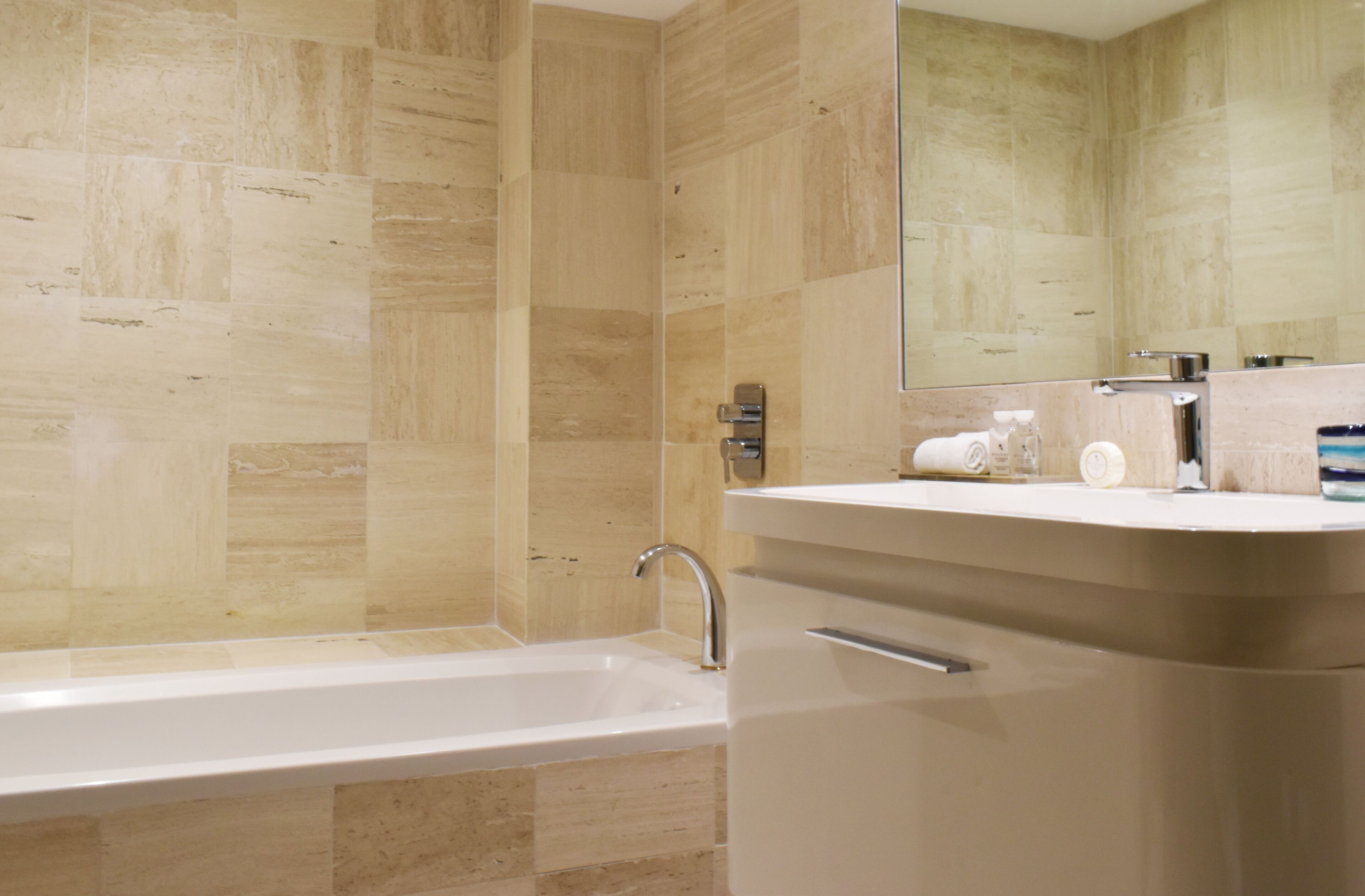 Un baño moderno con bañera, lavabo y espejo.