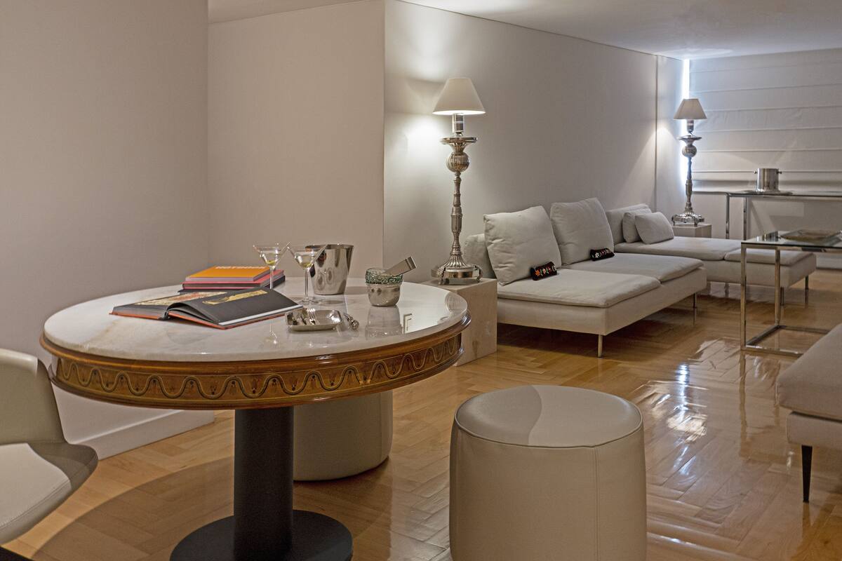 A modern living room with a round coffee table, a sofa, and a glass table.