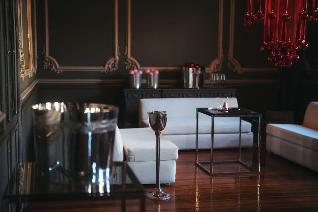 A room with a white sofa, a glass coffee table, and a decorative metal bowl.
