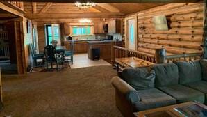 A log cabin interior with a dining area, kitchen, and living room. - Beautiful Log Cabin 11ac. 4 br. 2.5 ba. on snowmobile trails in Manistee forest. (Township of Branch)