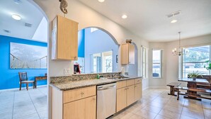 A modern kitchen with a granite countertop, wooden cabinets, and a dishwasher. - Dog-Friendly Kissimmee Home w/ Lanai + Pool! (Kissimmee)