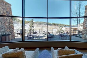 Enjoy a view of the outdoor patio area from the comfort of this room, featuring a barbecue grill and comfortable seating.