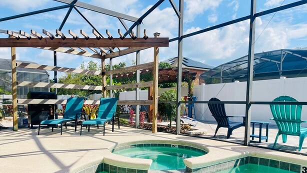 A pool area with a pergola, lounge chairs, and a glass-enclosed structure. - 🌿Welcome to the Jungle🌿 (Davenport)