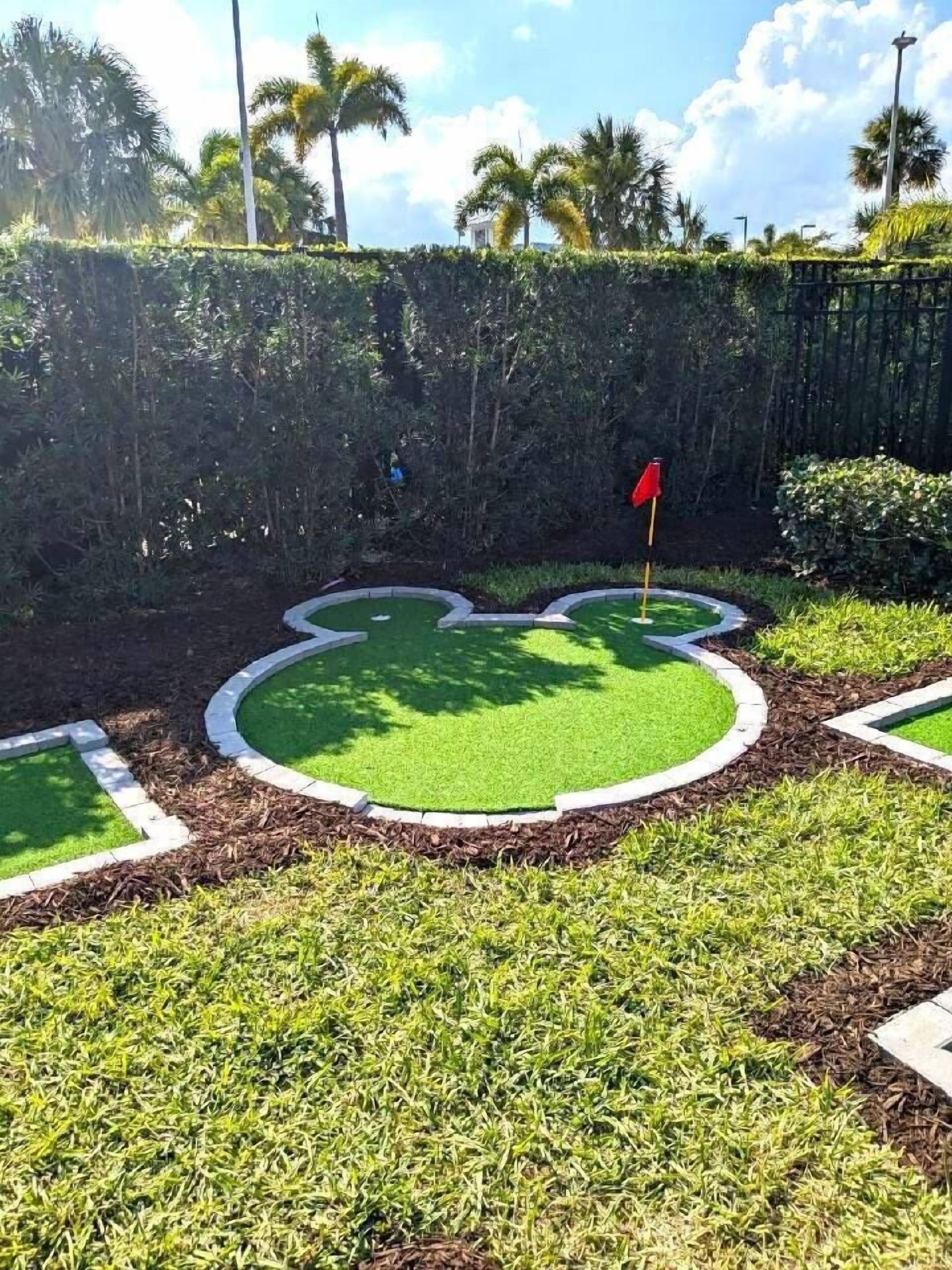 En minigolfbane med en hjerteformet putting green og et rødt flag.