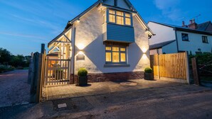A two-story house with a gabled roof, a front porch, and a wooden gate. - Pilgrim Cottage - Luxury Cottages (Chester)
