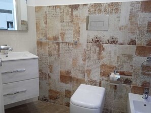 Ein Badezimmer mit weißem Waschbecken, Toilette und Spiegel.