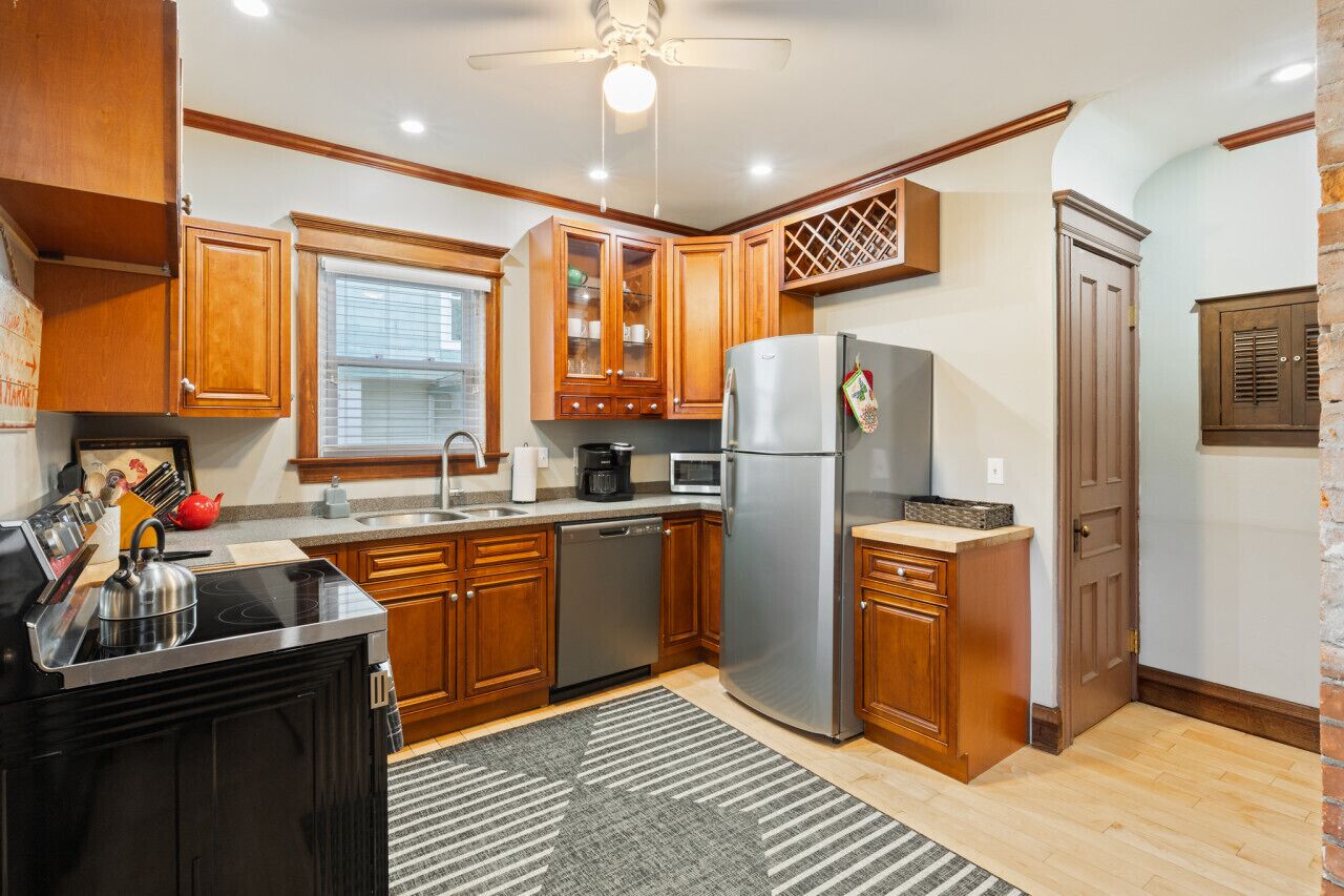 A kitchen with wooden cabinets, stainless steel appliances, a dishwasher, and a refrigerator.