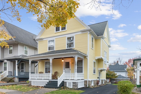 A two-story house with a porch, a front door, and a number '29' on the side. - Spacious 4 BDRM w/Onsite Parking & A/C! (Rochester)