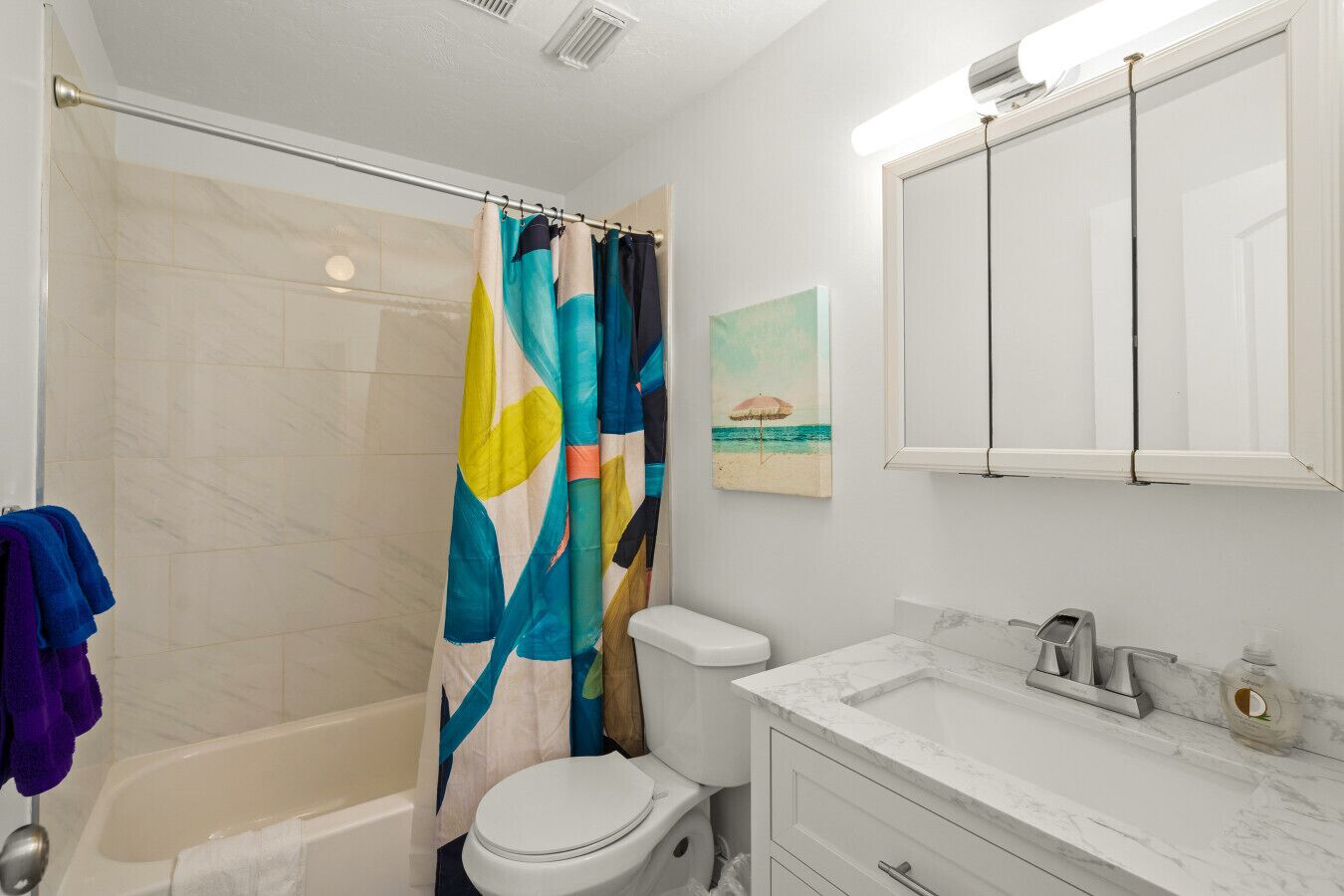 A bathroom with a shower, toilet, and sink.